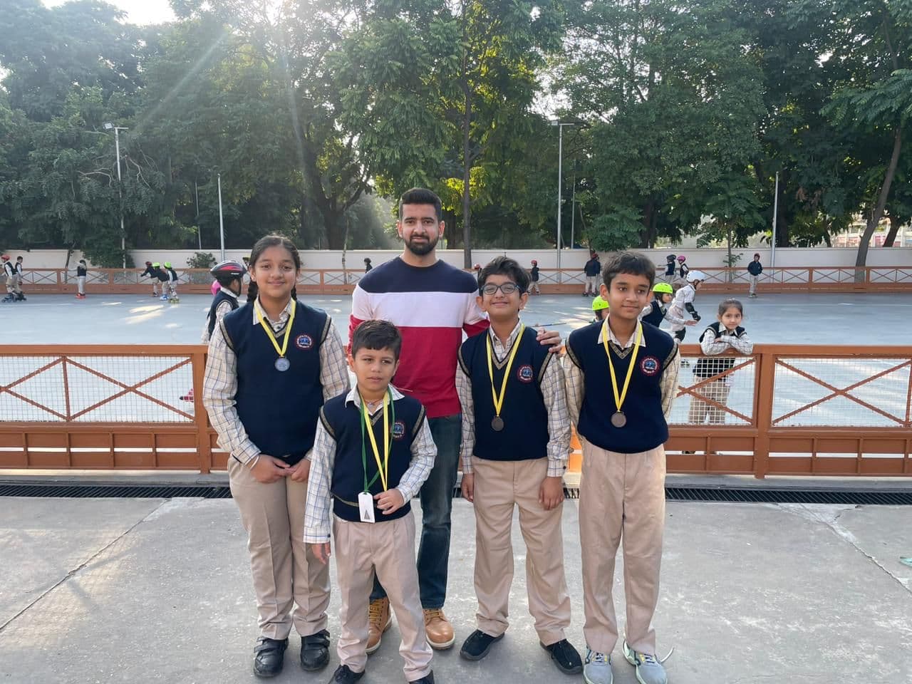Parth at the skating rink with four of his students wearing their medals