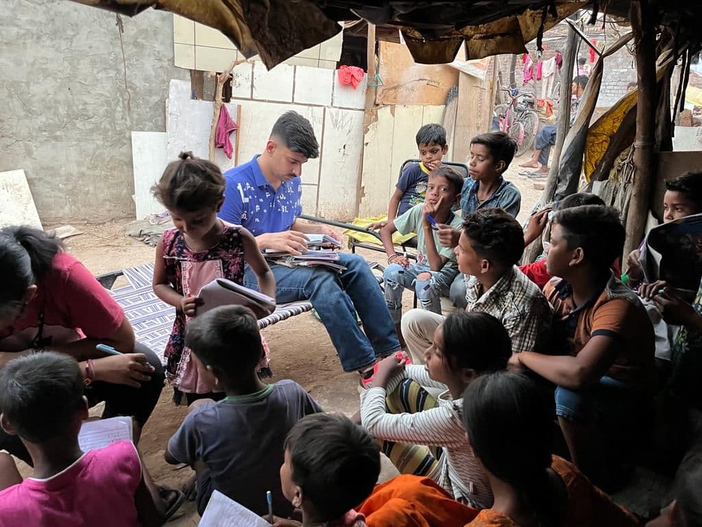 Parth reading with a circle of children in Jagatpura village